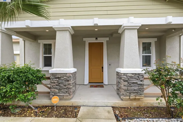 a front view of a house with plants
