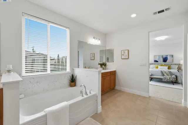 a bathroom with a tub a sink and a window