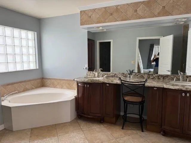 a bathroom with a bathtub a sink a mirror and a window