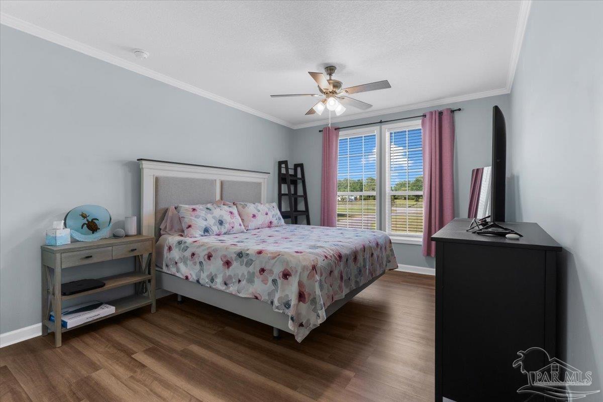 4955 Blue Ribbon Drive Milton, FL 32583 - Photo 16 of 32 a bedroom with a large bed and a chandelier