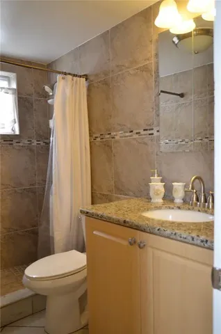 a bathroom with a granite countertop sink a toilet and a mirror