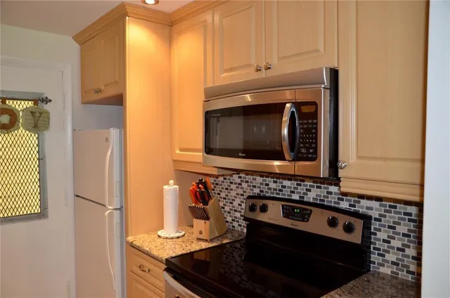 a kitchen with granite countertop a stove and a microwave