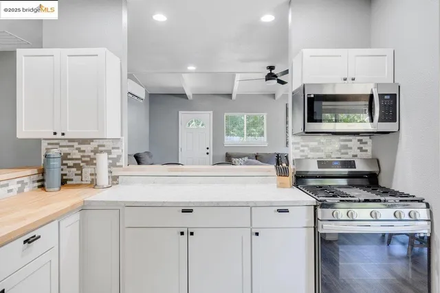 a kitchen with stainless steel appliances granite countertop a stove a sink and a microwave