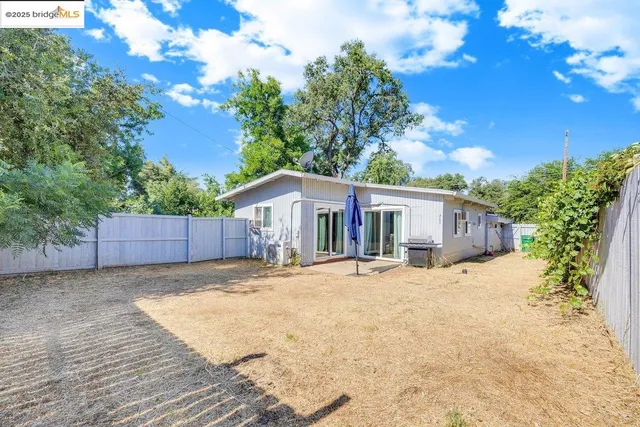 a backyard of a house with table and chairs