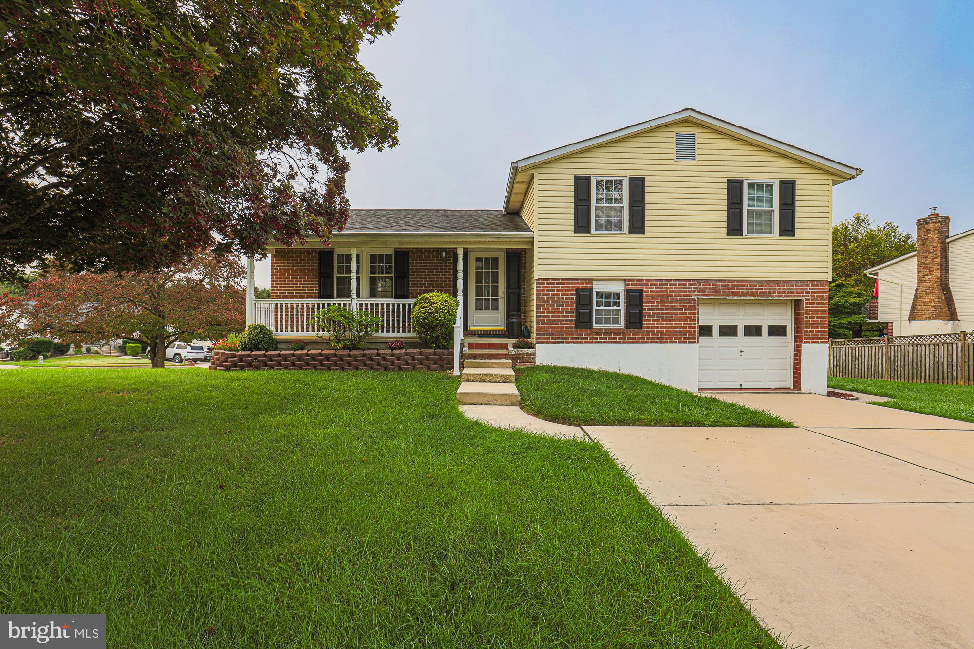 a front view of a house with a yard and trees