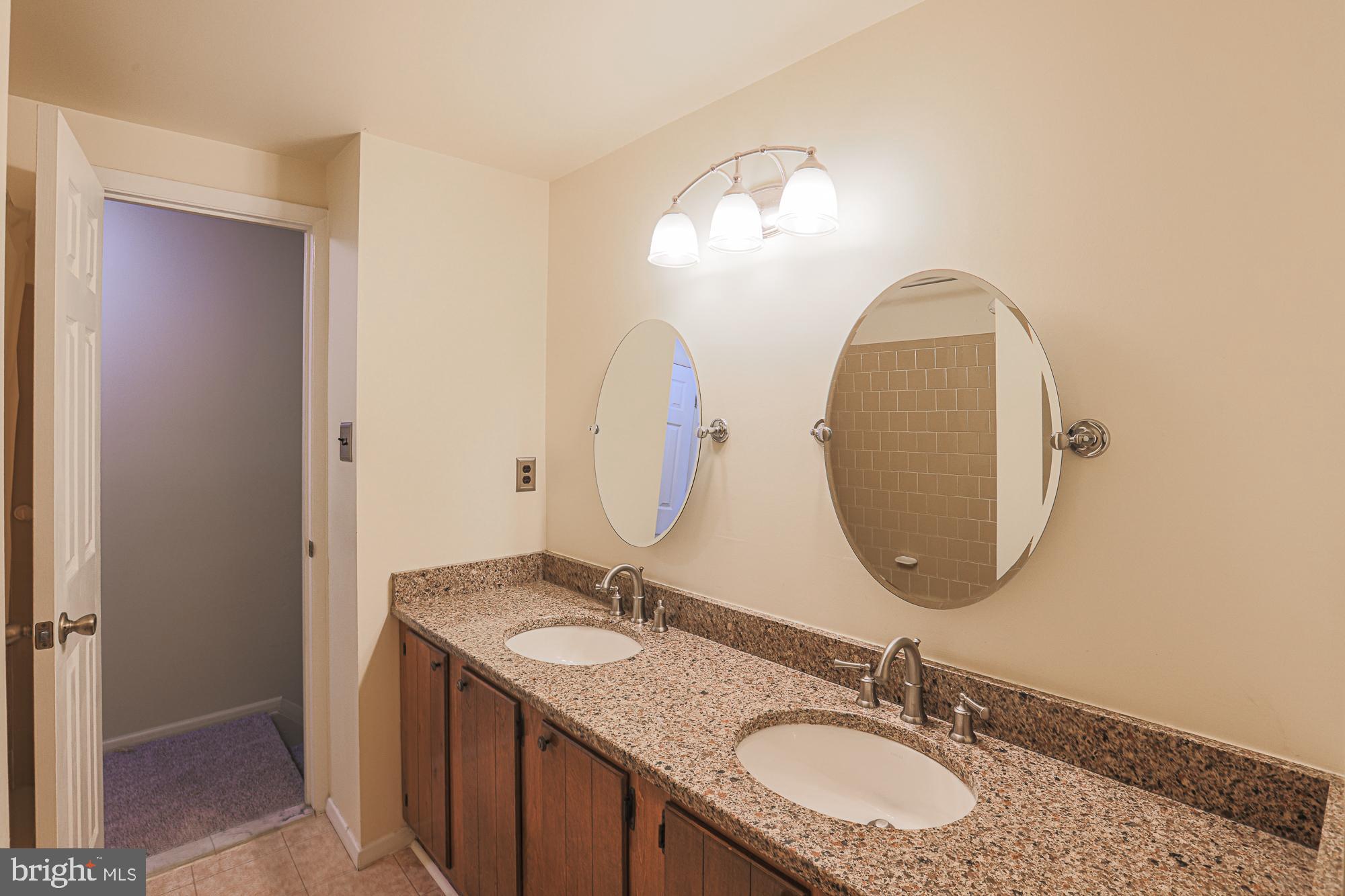 3923 Millner Road Baltimore, MD 21236 - Photo 19 of 38 a bathroom with a granite countertop double vanity sinks and a mirror