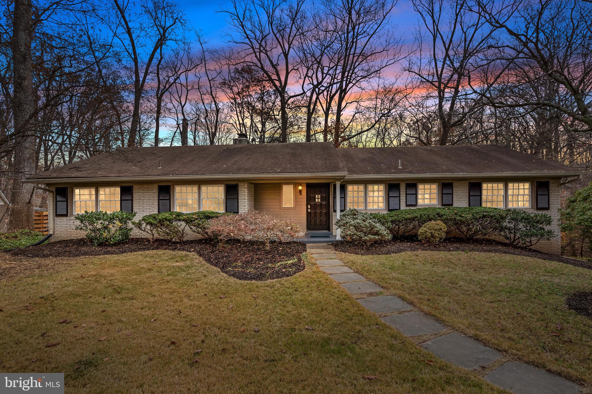 a front view of a house with yard and green space