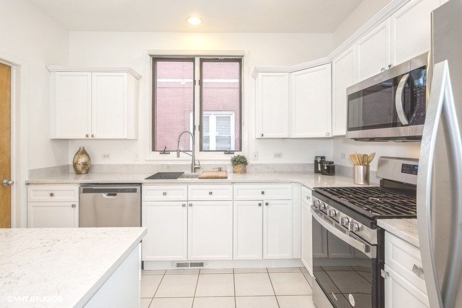 2002 West Potomac Avenue Chicago, IL 60622 - Photo 8 of 17 a kitchen with stainless steel appliances granite countertop a stove top oven a sink dishwasher and a microwave oven with large cabinets