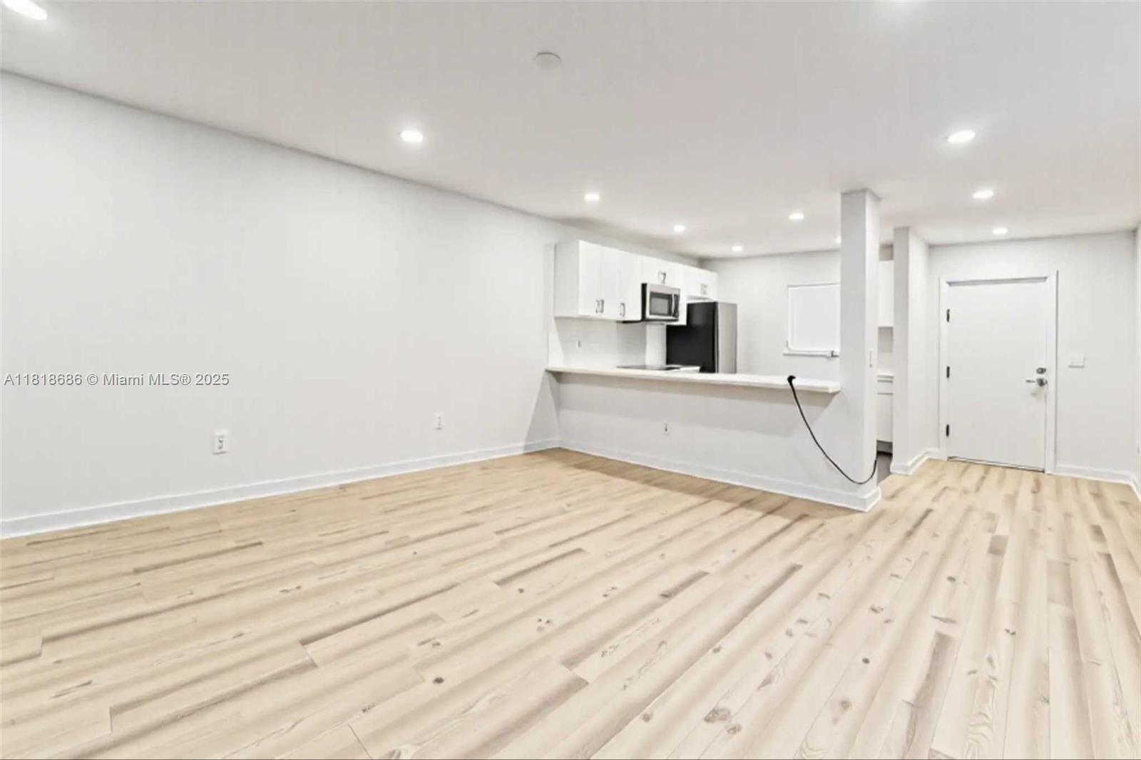 5790 Stirling Road, Unit 212 Hollywood, FL 33021 - Photo 11 of 22 a view of empty room with wooden floor and kitchen