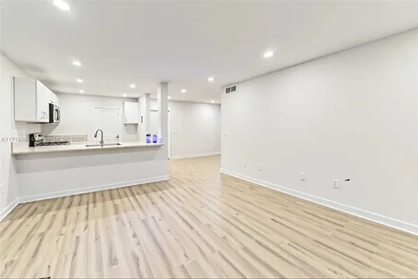 a kitchen with stainless steel appliances wooden floors and view living room