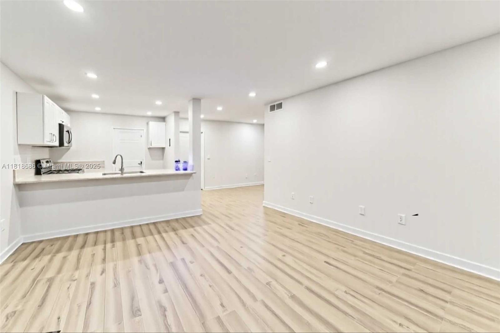5790 Stirling Road, Unit 212 Hollywood, FL 33021 - Photo 12 of 22 a kitchen with stainless steel appliances wooden floors and view living room