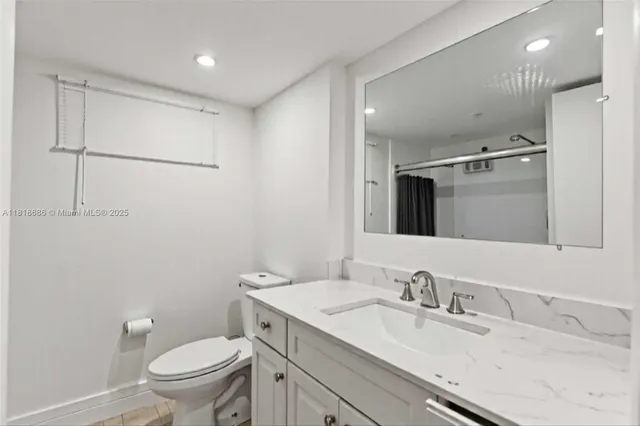 a bathroom with a granite countertop sink toilet and shower
