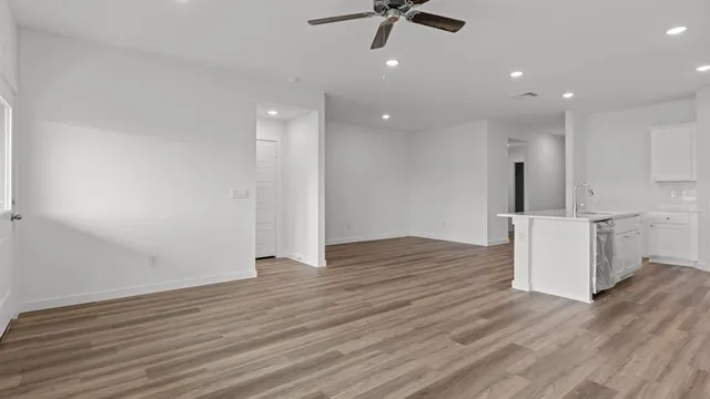 a view of a kitchen with a sink and wooden floor
