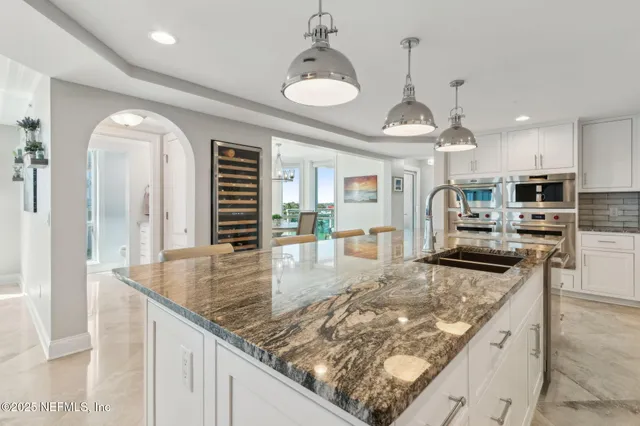 a living room with furniture a chandelier and a dining table