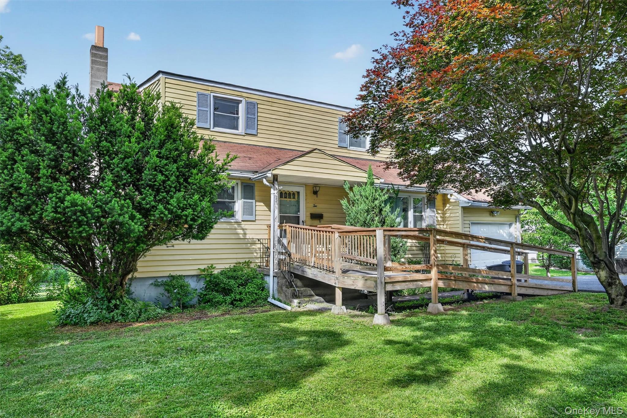 2 Curie Road Cornwall-on-Hudson, NY 12520 - Photo 2 of 37 Two-story residence featuring light yellow siding, a wood ramp entry, and an integrated garage