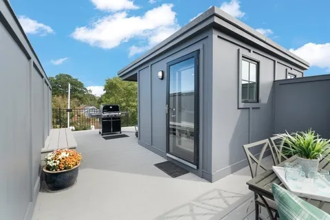 a view of a hallway with wooden floor and white walls