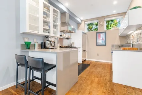 a kitchen with a table chairs refrigerator and cabinets