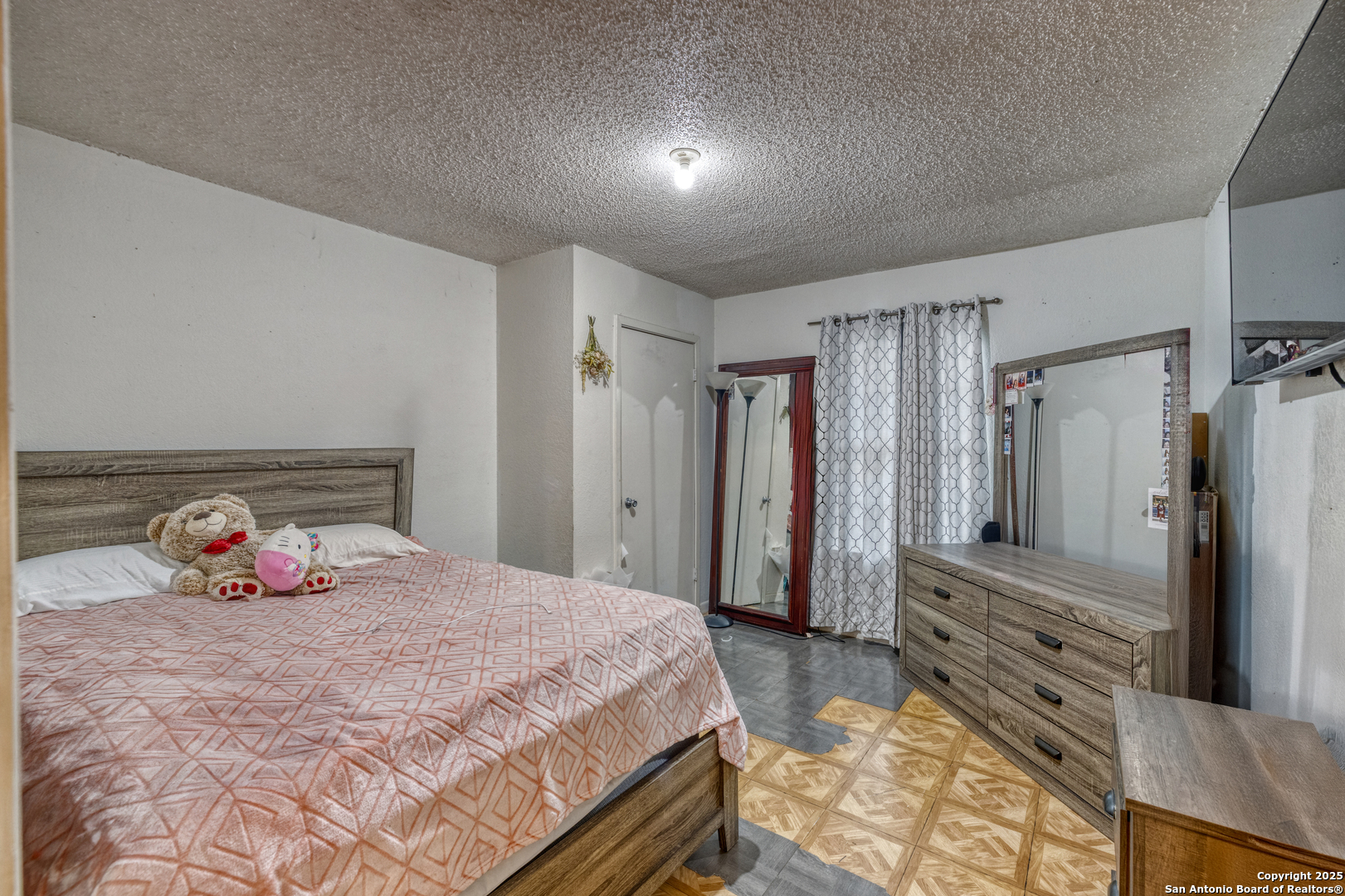 258 Prairie Street Uvalde, TX 78801 - Photo 8 of 19 a bedroom with a bed and a large mirror
