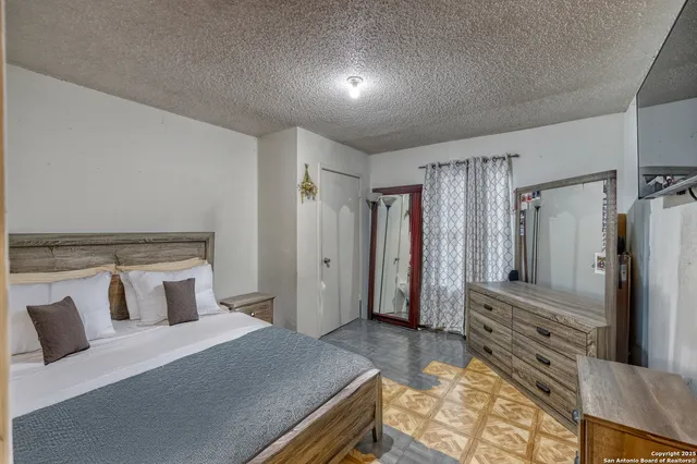 a bedroom with a large bed and a dresser