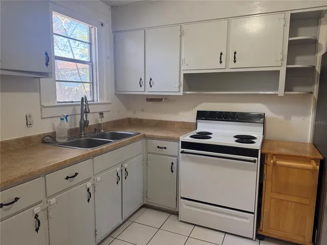 a kitchen with cabinets appliances a sink and a window