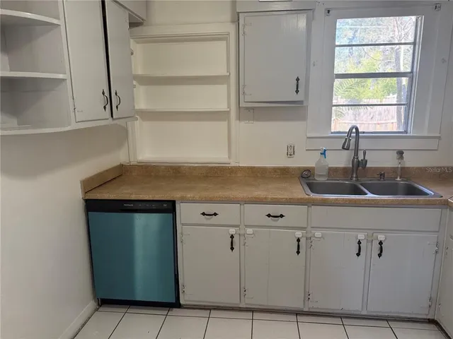 a kitchen with granite countertop white cabinets and a sink