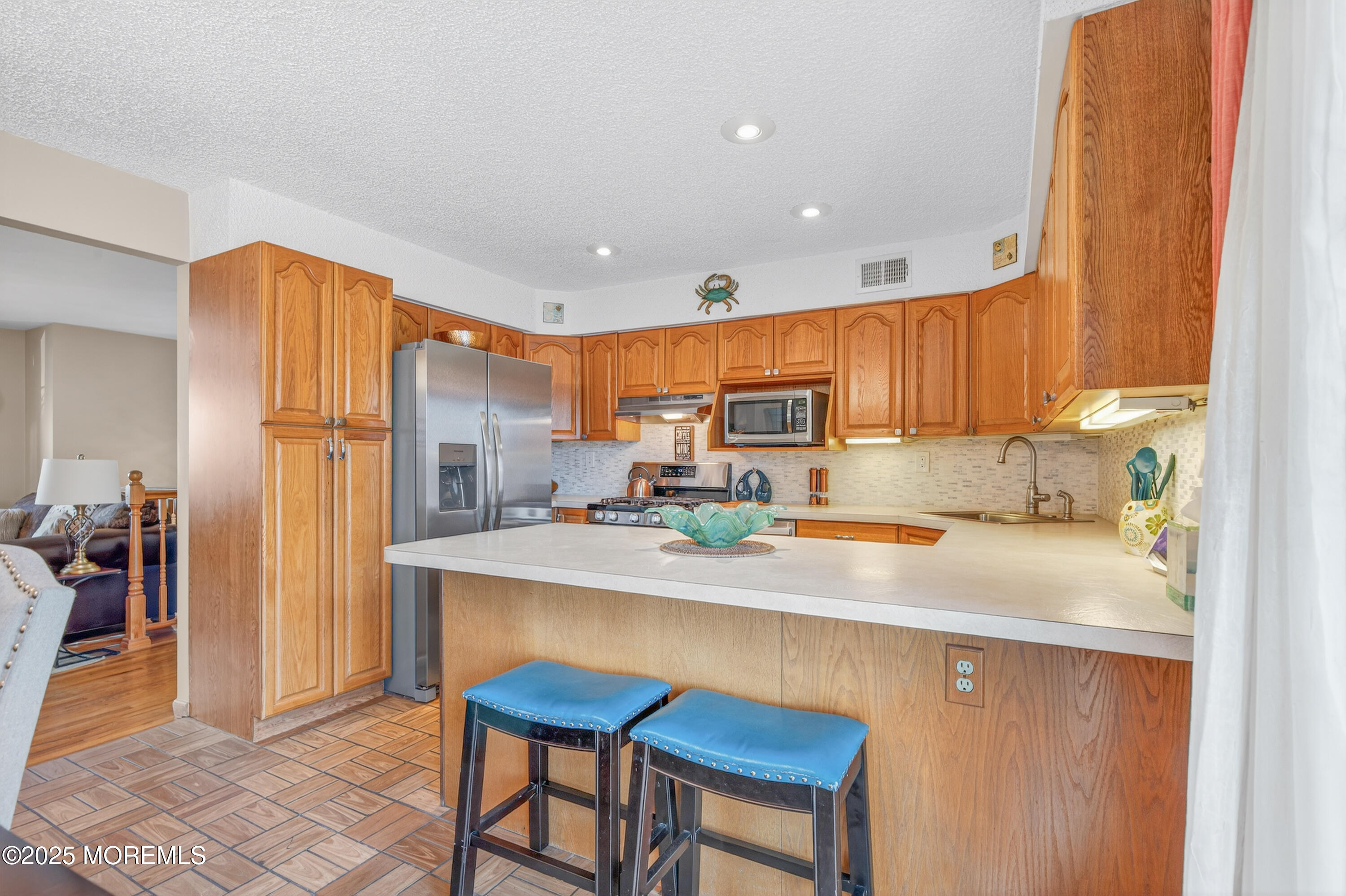 35 Heather Road Toms River, NJ 08753 - Photo 12 of 40 a kitchen with stainless steel appliances a sink a stove a refrigerator cabinets and dining table