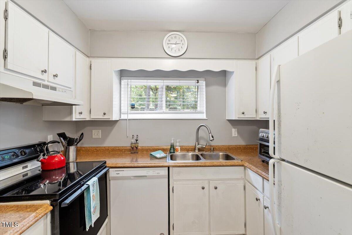 712 Godwin Court Raleigh, NC 27606 - Photo 4 of 27 a kitchen with stainless steel appliances granite countertop a sink stove and cabinets