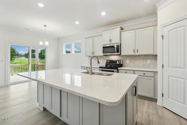 a kitchen with a sink a stove and a refrigerator
