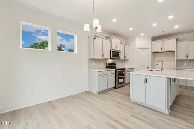 a view of an empty room with wooden floor fireplace and a window