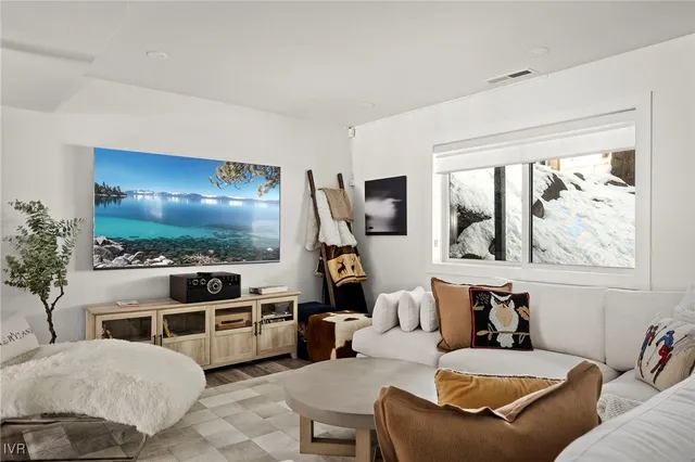 a living room with furniture a flat screen tv and a potted plant
