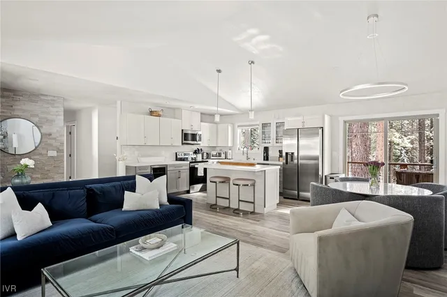 a living room with furniture kitchen view and a window