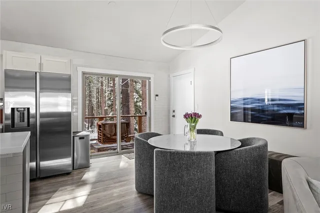 a dining room with furniture and a floor to ceiling window