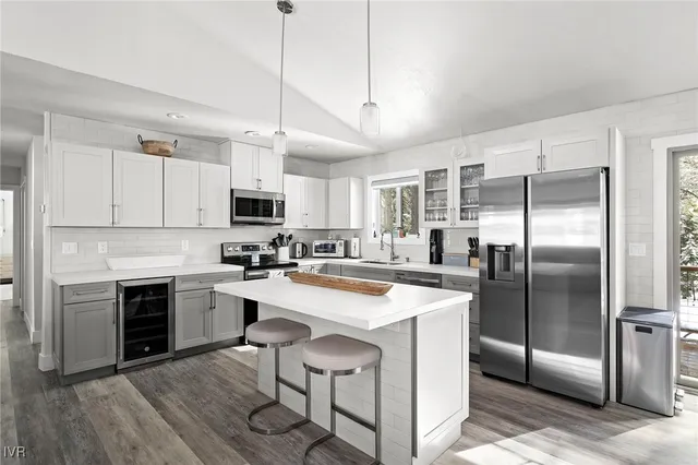 a kitchen with kitchen island a stove a sink and a refrigerator