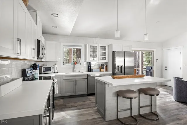 a kitchen with kitchen island granite countertop a sink and cabinets