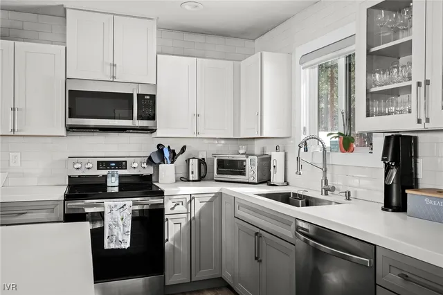 a kitchen with cabinets appliances a sink and a counter top space