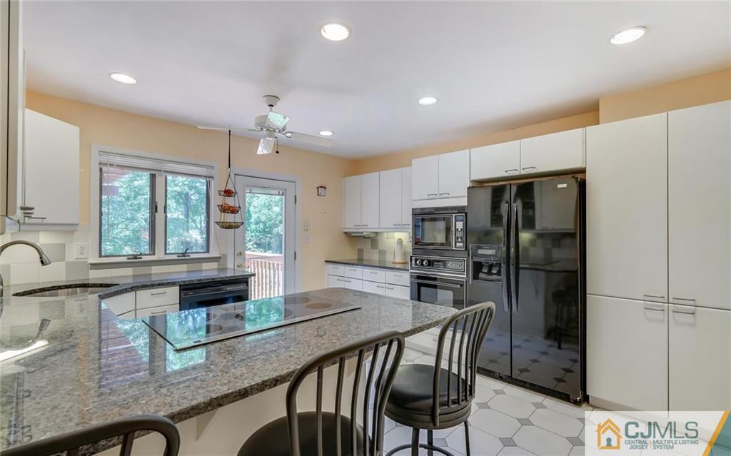 21 Peake Road Edison, NJ 08837 - Photo 5 of 24 a kitchen with stainless steel appliances granite countertop table chairs refrigerator and microwave
