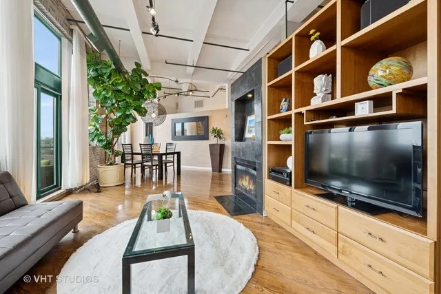 a living room with furniture a flat screen tv and a floor to ceiling window