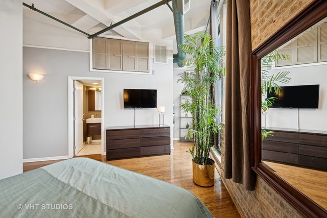 2222 West Diversey Avenue, Unit 407 Chicago, IL 60647 - Photo 14 of 30 a bedroom with a bed and a television