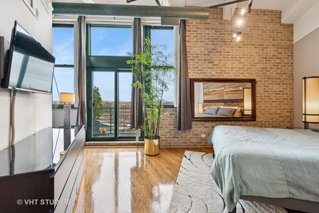 2222 West Diversey Avenue, Unit 407 Chicago, IL 60647 - Photo 15 of 30 a bedroom with a bed and a fireplace