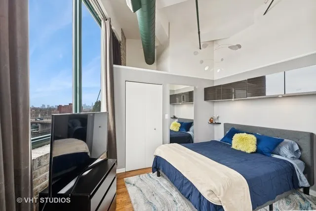 a bedroom with a bed and wooden floor