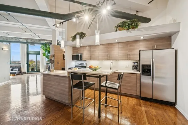 a kitchen with granite countertop a table chairs stove and refrigerator