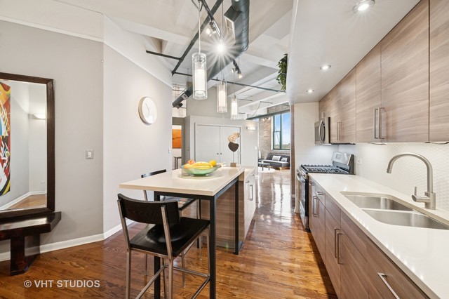 2222 West Diversey Avenue, Unit 407 Chicago, IL 60647 - Photo 5 of 30 a kitchen with stainless steel appliances granite countertop a kitchen island a stove a table and chairs