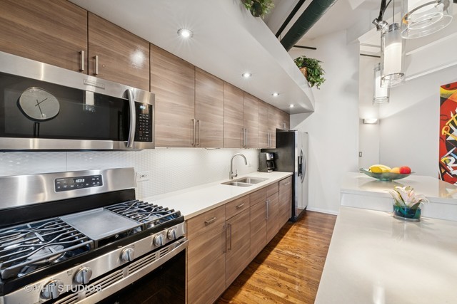 2222 West Diversey Avenue, Unit 407 Chicago, IL 60647 - Photo 6 of 30 a kitchen with a stove and a microwave