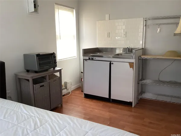 a kitchen with granite countertop cabinets stainless steel appliances and a wooden floor
