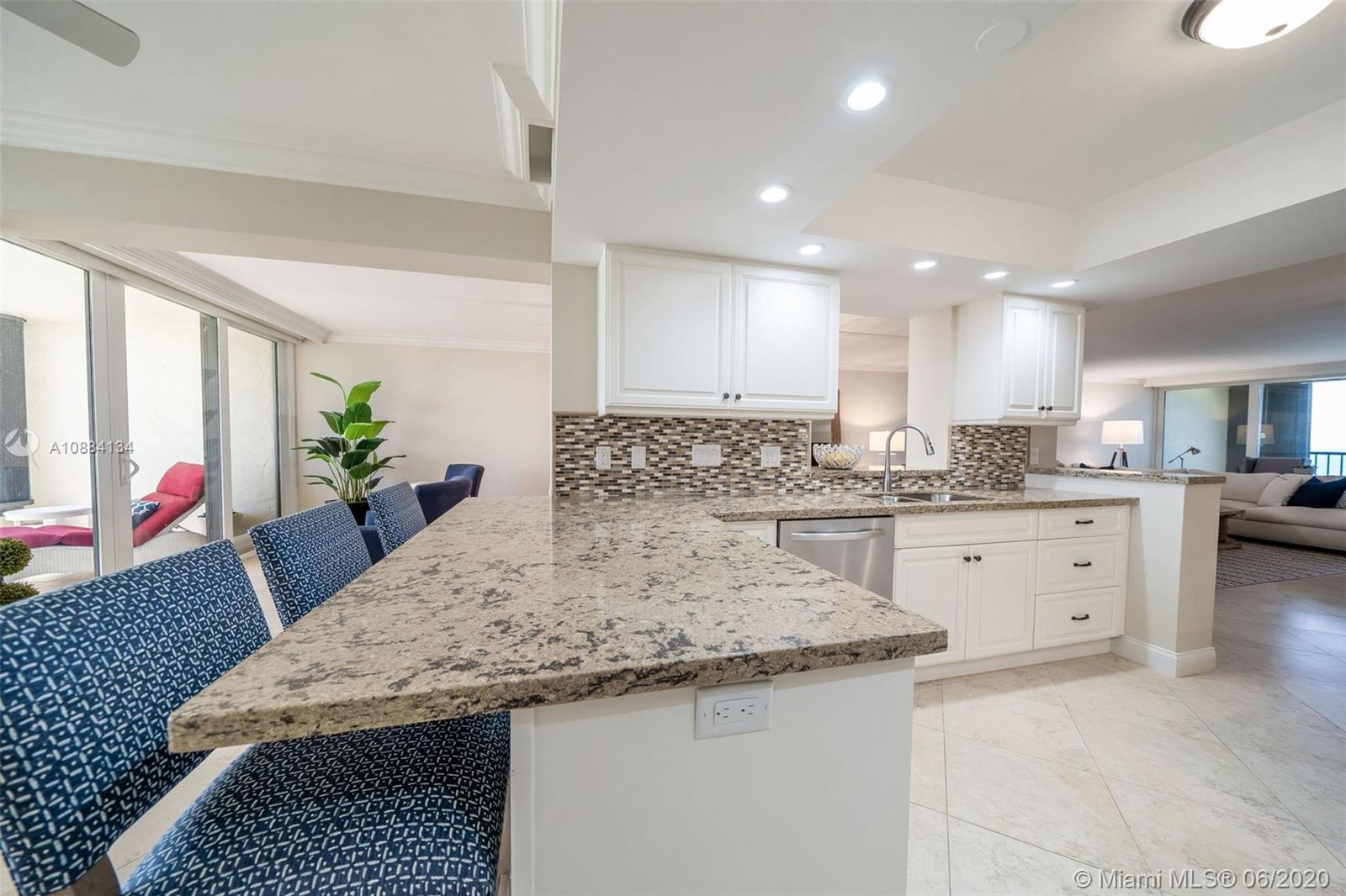19900 South Beach Road, Unit 803 Jupiter, FL 33469 - Photo 15 of 64 a kitchen with granite countertop wooden cabinets a stove a sink and a granite counter top