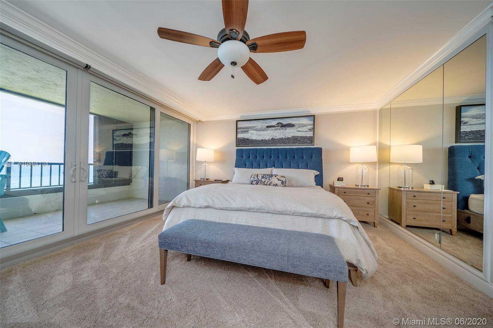 19900 South Beach Road, Unit 803 Jupiter, FL 33469 - Photo 33 of 64 a bedroom with a large bed and a chandelier