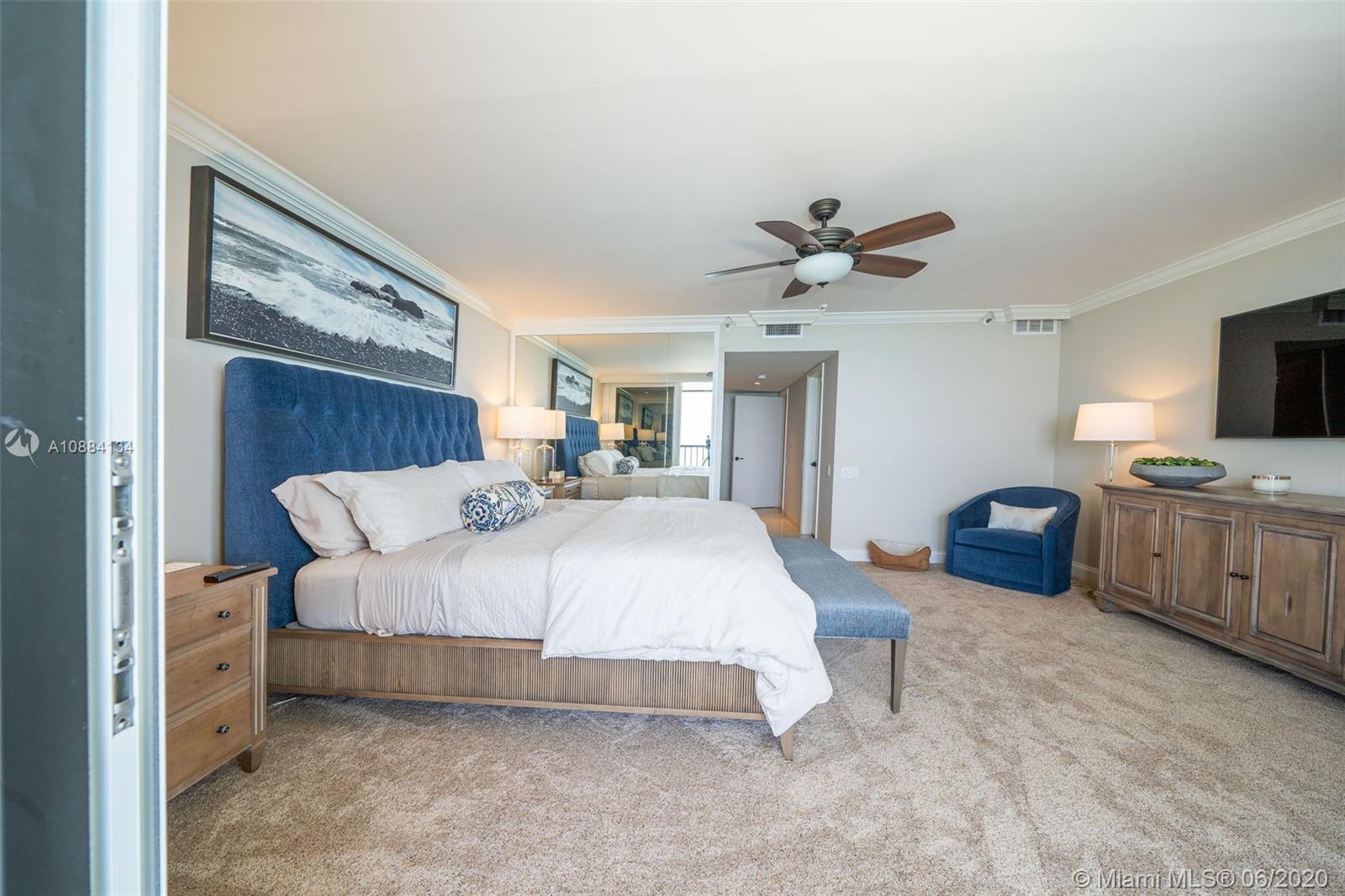 19900 South Beach Road, Unit 803 Jupiter, FL 33469 - Photo 36 of 64 a spacious bedroom with a bed a couch and a ceiling fan