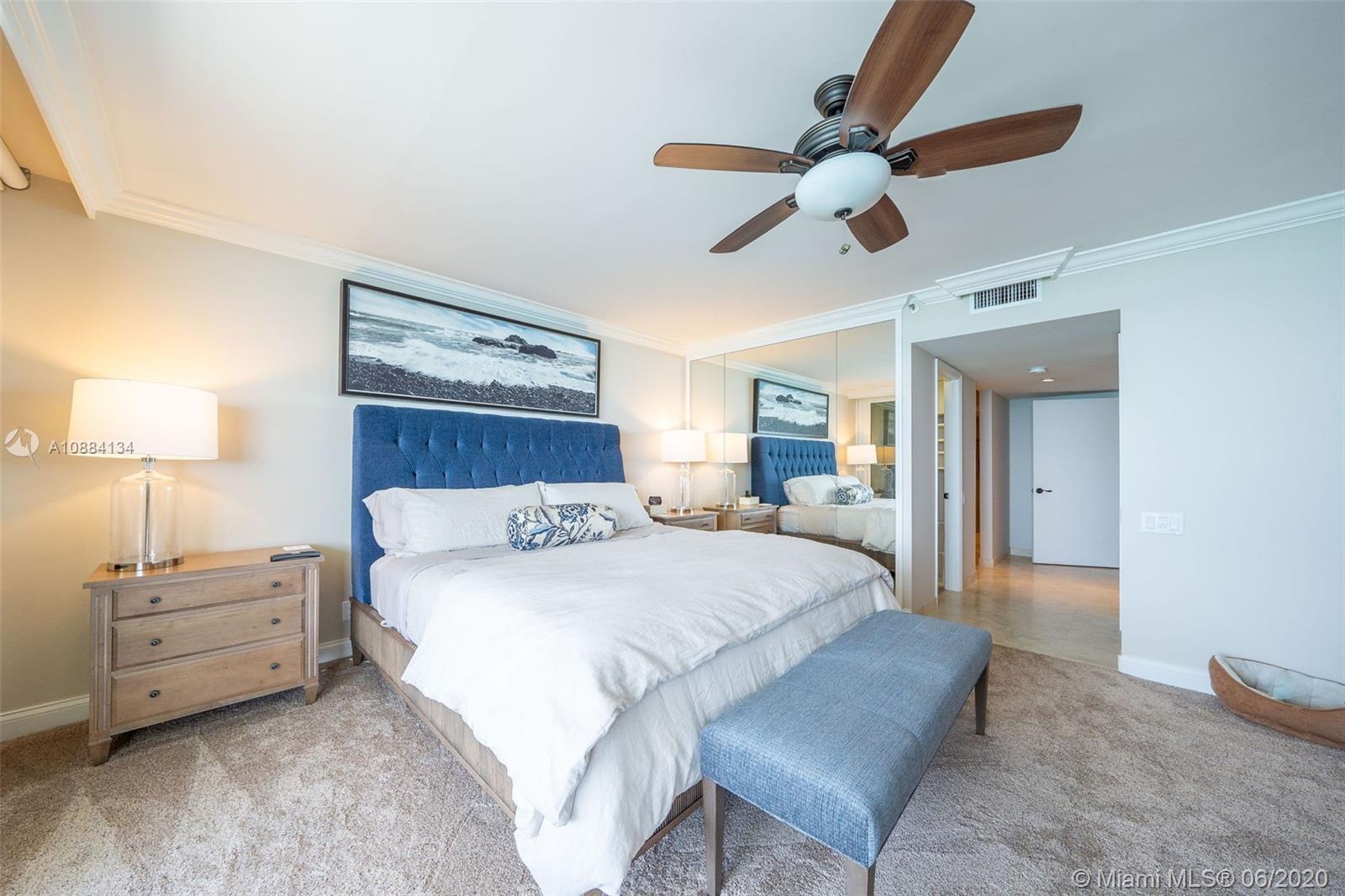 19900 South Beach Road, Unit 803 Jupiter, FL 33469 - Photo 37 of 64 a bedroom with a large bed and a chandelier