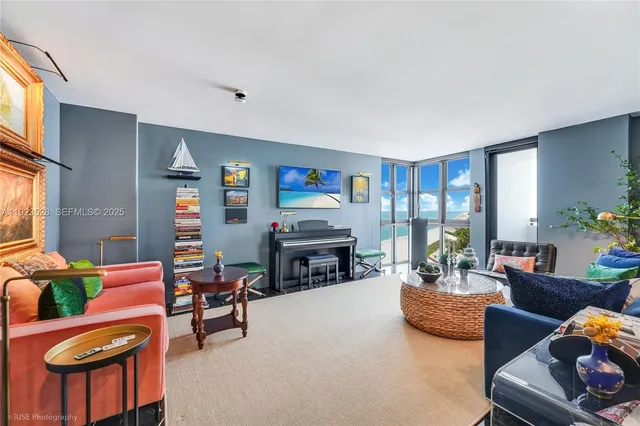 a living room with furniture a fireplace and a large window