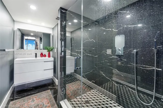 a bathroom with a sink mirror and shower